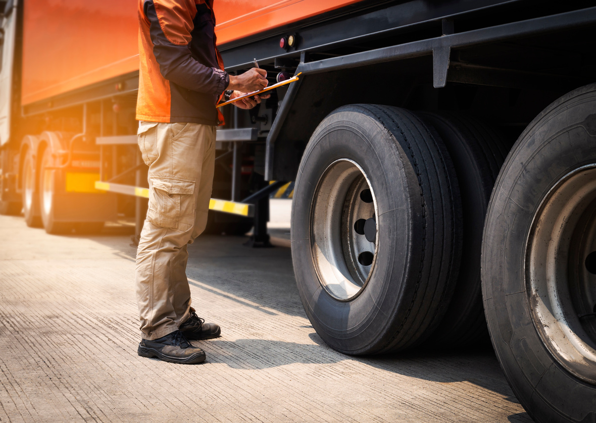 truck driver is inspecting safety tires truck.